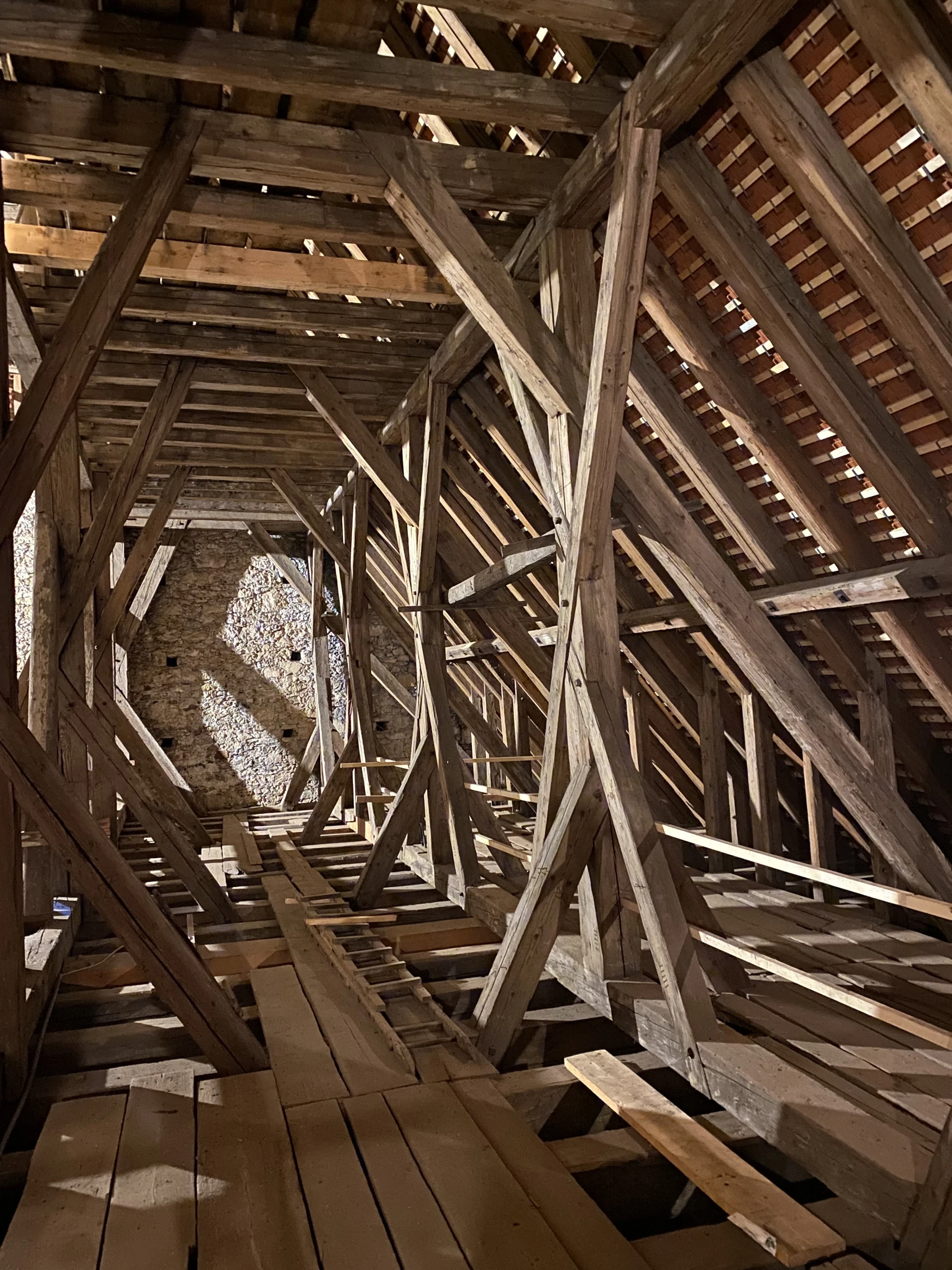 Blick in den mittelalterlichen Dachstuhl des Neuberger Münsters mit hölzernem Laufsteg und mächtigen Balken
